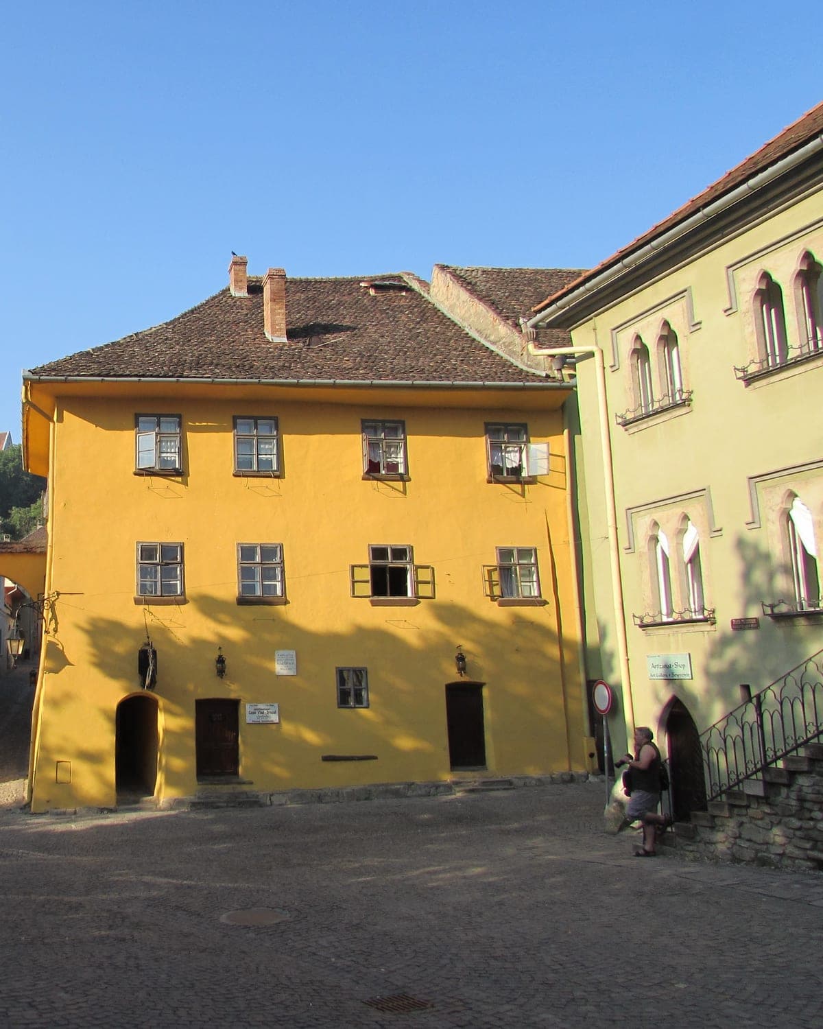 Yellow façade of Casa Vlad Dracul on a cobblestone corner of the Sighișoara citadel
