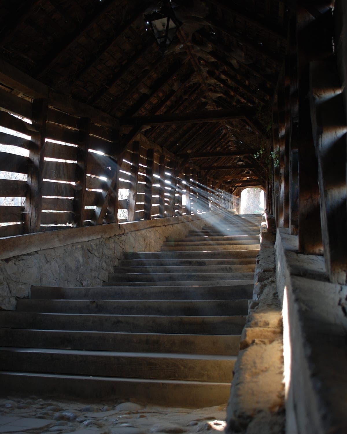 Sunbeams falling through the slatted walls of the Covered Staircase tunnel in Sighișoara